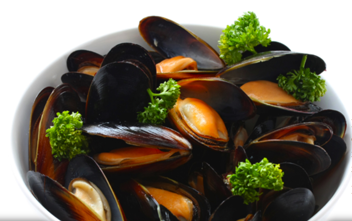 a dish of steamed mussles with parsley